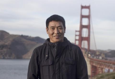 Dhondup Wangchen standing before the Golden Gate Bridge