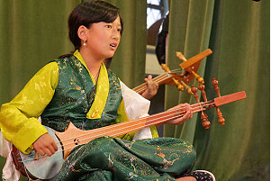 Girl playing Tibetan instrument